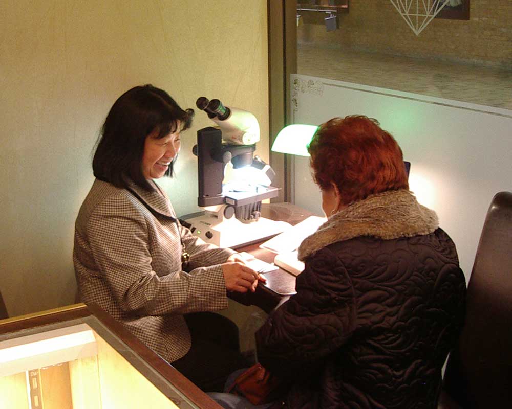 two women sitting together at a desk smiling