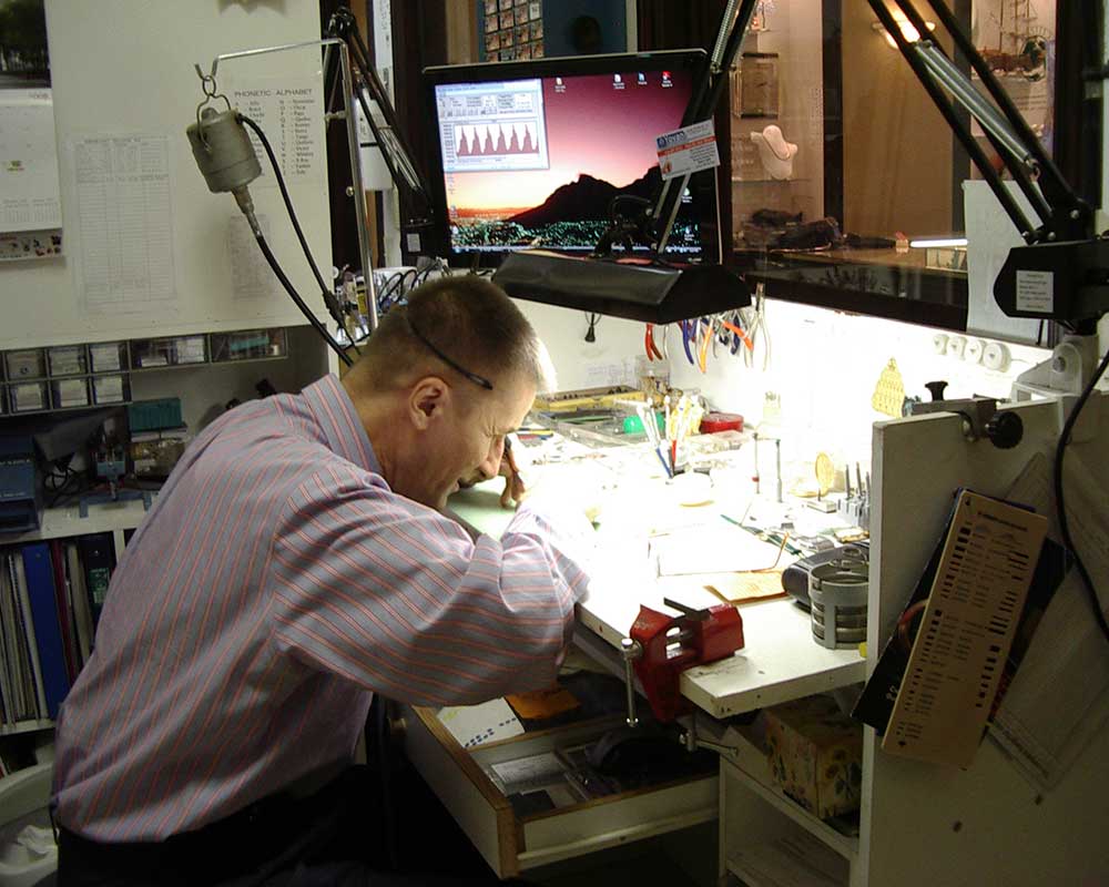 watchmaker repairing watches underneath a light